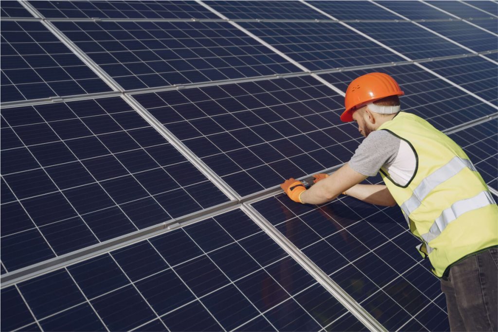 Solar engineer installing high-efficiency solar panels on a UK project site